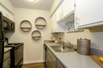 a kitchen with white cabinets and a stainless steel sink